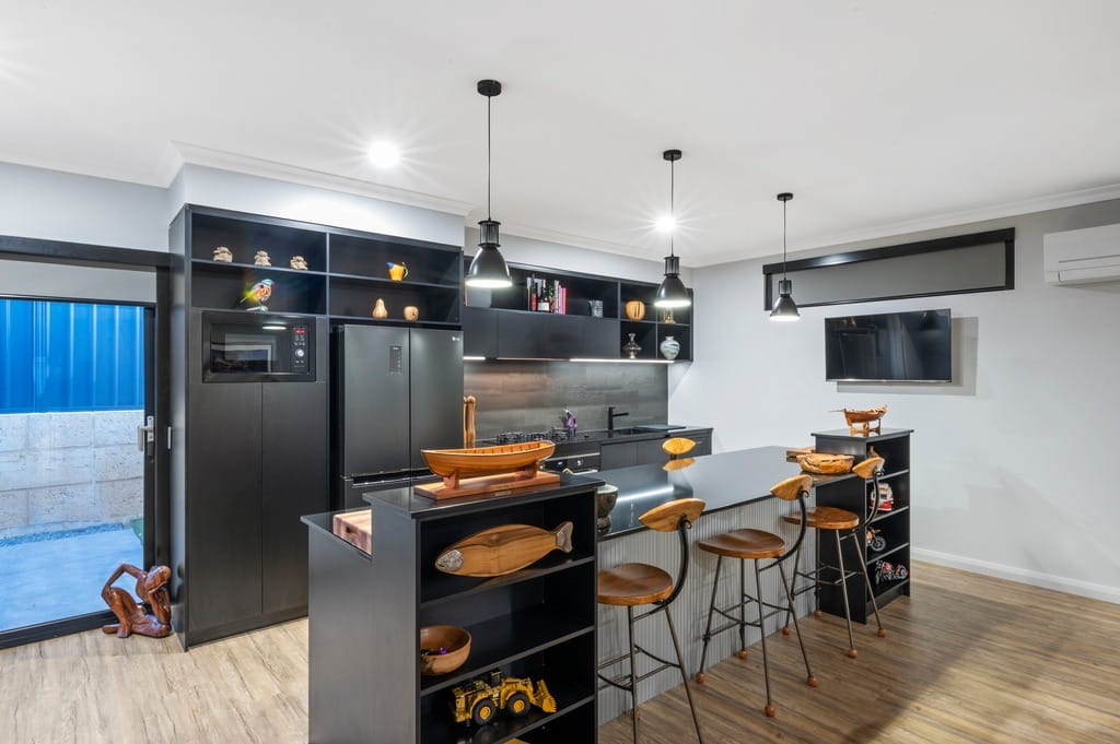 Kitchen in Makin Homes' Sandalwood Avenue project with recessed downlights and black pendant lights over the stone benchtop
