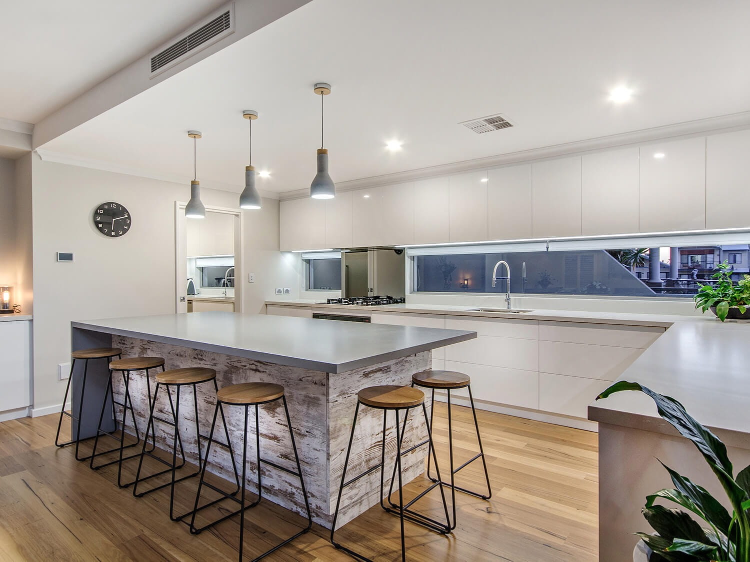Luxury kitchen with pendant lighting over an oversized island bench and a butler's pantry
