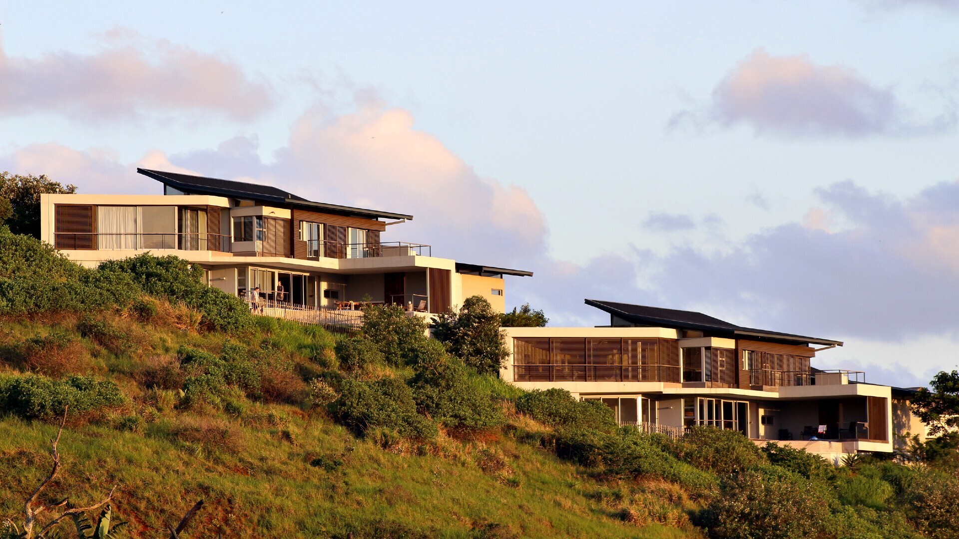 Contemporary hillside luxury homes with expansive balconies designed to capture coastal views.