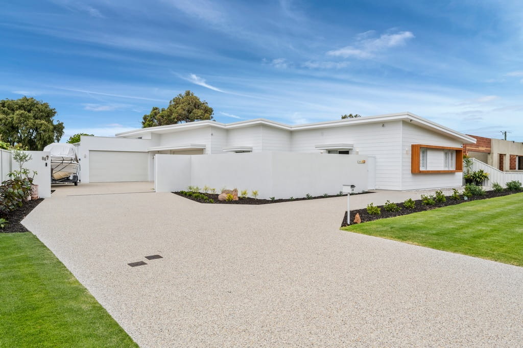 Contemporary white single-storey home with landscaped front garden and wide driveway